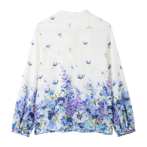 Rear view of white women's shirt featuring blue-purple floral prints and bow closure