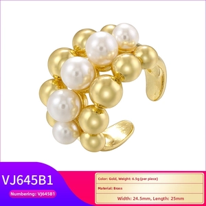 Macro shot of gold brass beads and white pearls on an irregular woven ring band