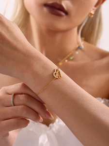 Gros plan d'un bracelet coeur doré avec gravure MAMMA et pierres de zircon scintillantes