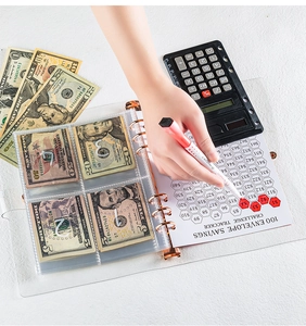 User marking a 100 envelope savings challenge tracker in a PVC binder with cash envelopes