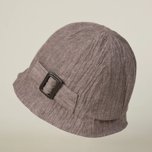 Detailed view of brown linen bucket hat showing vertical ribbed texture and buckle strap
