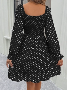 Detail of the elastic shirred back and ruffled hem on a black polka dot long sleeve dress