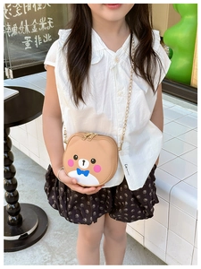 Detail of cartoon bear crossbody bag with gold chain strap and dual zipper closure