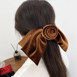 Vue détaillée d'une pince à cheveux rose en velours marron portée avec élégance