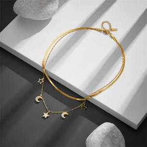 Detail of double-layer stainless steel gold necklace with moon and star shell charms