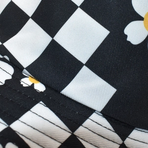 Detail of sunflower print on checkerboard bucket hat with reinforced stitching