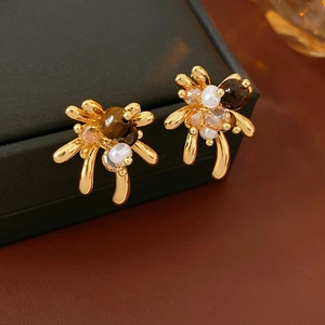 Gros plan de boucles d'oreilles vintage en or avec oeil de tigre et perles sur boîte