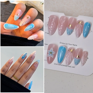 Detail of 3D shell texture and floral charms on pink and blue gradient press-on nails
