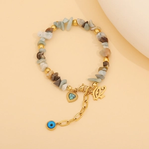 Detail view of bohemian beaded bracelet with natural stones and evil eye heart charms