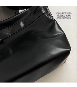 Détail de la texture en similicuir noir et des coutures sur ce grand sac fourre-tout