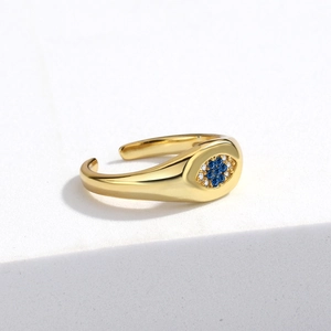 Detailed view of evil eye ring with blue zircon inlay on white stone surface