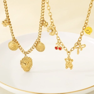 Gold stainless steel necklaces with lion, bear, and floral charms on white plate