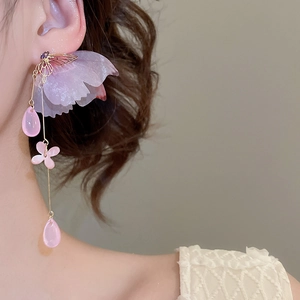 Detail of silver needle earrings with tulle flowers and pink butterfly tassels
