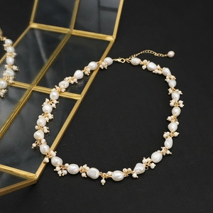Baroque pearl necklace with irregular natural beads and gold chain on black background