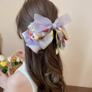 Detail of oversized bow hair claw with vintage floral fabric and purple organza ribbon