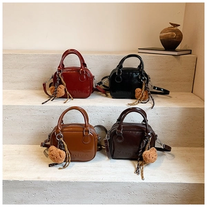 Detailed display of four vintage leather Boston bags in various colors on steps