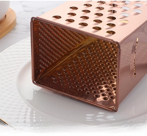 Macro shot of rose gold stainless steel grater with reinforced rolled edges for safety
