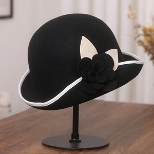 Macro detail of wool cloche hat with contrast brim and camellia floral embellishment