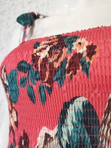 Macro shot of magenta summer dress with vintage rose print and elastic smocking fabric