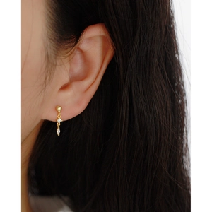 Detail of s925 silver long drop earring with sparkling zircon stones worn by a model