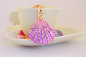 Close-up of pink shell keychain with enamel finish and sparkling crystal edges