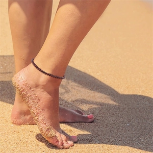 Fashionable 4mm deep red garnet beaded anklet worn on a sandy beach for a boho look
