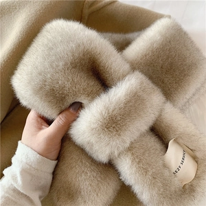 Detailed view of plush faux rabbit fur scarf with decorative label and cross-loop style