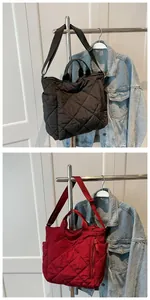 Detail of quilted tote bag featuring classic diamond patterns and side pocket utility