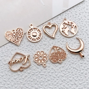 Eight assorted antique gold metal charms featuring heart sun moon and tree patterns