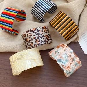 Macro detail of vertical striped acrylic cuff bracelets in various stylish patterns