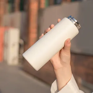 Close-up of matte cream-colored stainless steel insulated bottle with sleek metallic lid