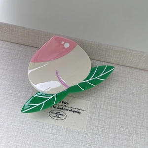 Detail of a peach-shaped acetate hair claw clip with pink and beige glossy finish