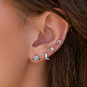 Detailed close-up of Western-style silver cowboy boot, hat, and sheriff star stud earrings