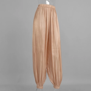 Detail of champagne gold pleated harem pants with a metallic luster and elastic ankle cuffs