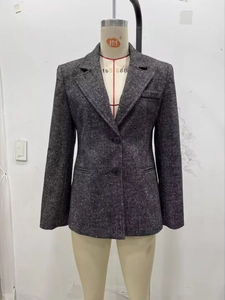 Vista dettagliata del blazer in tweed grigio scuro con trama a spina di pesce e bottoni