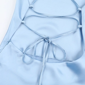 Détail de la robe en satin bleu clair avec laçage croisé au dos et fermeture éclair latérale
