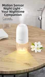 Detail view of white mist diffuser with soft yellow night light on wooden surface