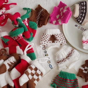 Detailed macro of festive mini knitted Christmas sweater ornaments and doll accessories