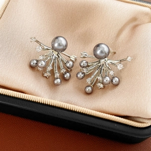 Detail of silver branch pearl earrings with crystals on champagne velvet background