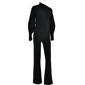 Detail of black knitted jumpsuit with high neck and long lantern sleeves on model