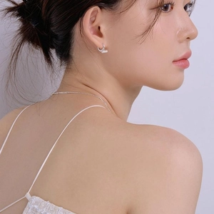 Close-up of minimalist S925 silver hoop earrings with three small pearls on model