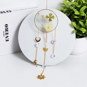 Detail of sun catcher with four-leaf clover crystal pendant and golden metal charms
