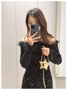 Close-up of star-shaped gold metal mini bag with chain strap and glossy finish