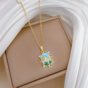 Detailed close-up of a luxury gold tulip enamel pendant with diamonds on silk background