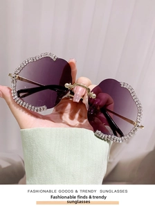 Dettaglio occhiali da sole senza montatura viola sfumati con bordi ondulati e strass