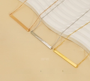 Vue détaillée de trois pendentifs barres en acier inoxydable poli or, argent et rose