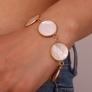 Detailed view of 18K gold plated OT buckle bracelet with white mother of pearl on wrist