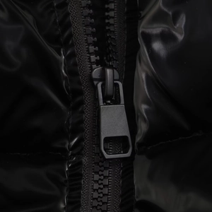 Detailed macro view of high-gloss waterproof fabric and premium black metal zipper puller