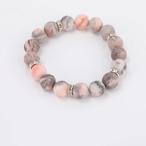 Macro detail of 8mm pink zebra jasper beads with crystal-studded silver spacers
