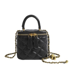 Quilted black leather mini square bag with golden chain and ball detail on white background
